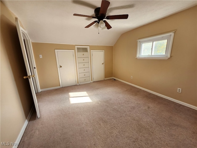 unfurnished bedroom featuring vaulted ceiling, carpet floors, a closet, and ceiling fan