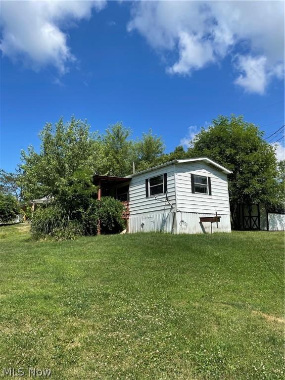 view of side of home with a lawn