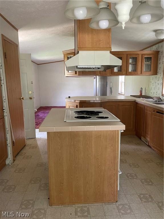 kitchen featuring a kitchen island, white gas stovetop, sink, and exhaust hood