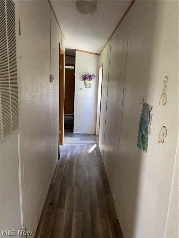 corridor featuring dark hardwood / wood-style flooring and crown molding