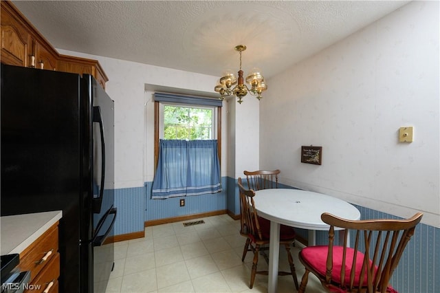 dining room featuring a textured ceiling and a notable chandelier