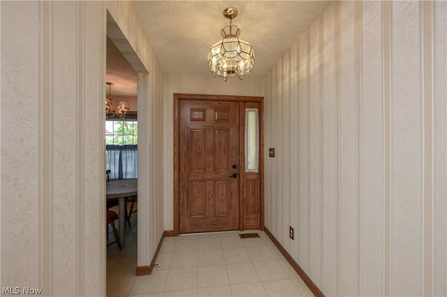 foyer featuring a textured ceiling and an inviting chandelier