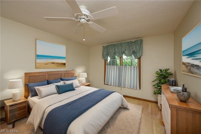 bedroom featuring ceiling fan, a textured ceiling, and light hardwood / wood-style flooring