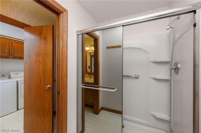 bathroom featuring separate washer and dryer and a shower with door