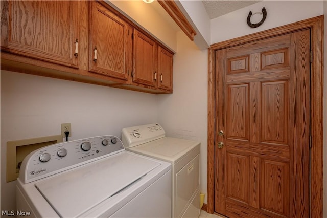 laundry room with cabinets, independent washer and dryer, and a textured ceiling