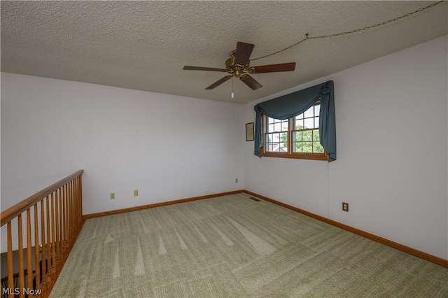 carpeted empty room with a textured ceiling and ceiling fan