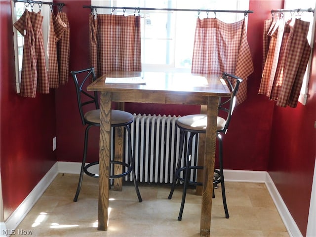 dining room featuring indoor bar and radiator