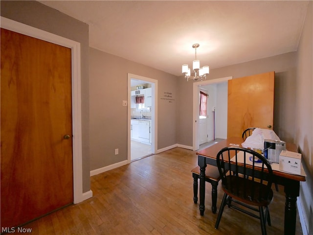 dining area with hardwood / wood-style floors and a chandelier