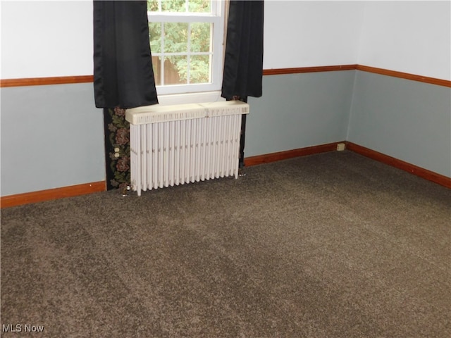 spare room with carpet and radiator heating unit