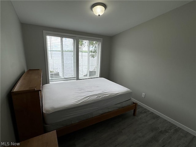 bedroom with dark hardwood / wood-style flooring