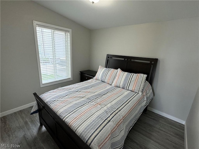 bedroom featuring dark wood-type flooring and vaulted ceiling