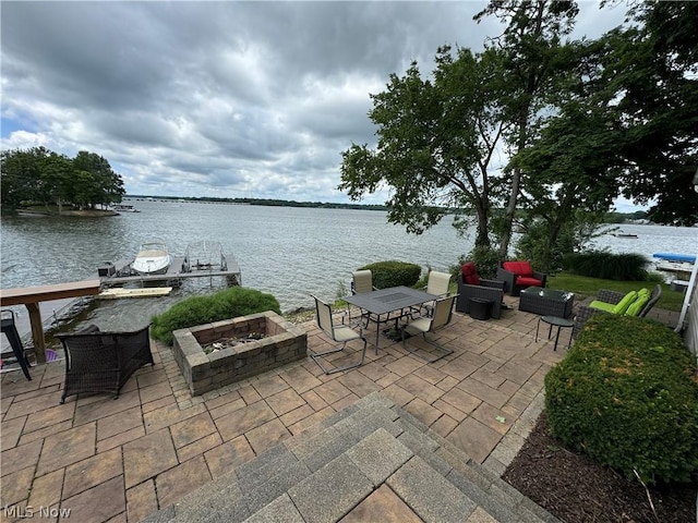 view of patio featuring a dock, a water view, and a fire pit