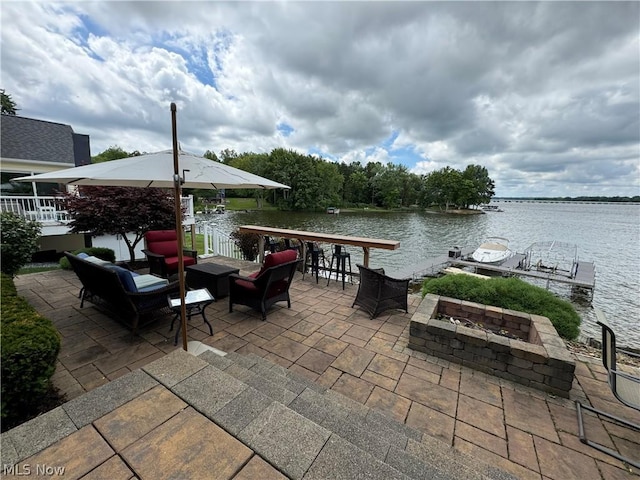 view of patio / terrace featuring a water view, an outdoor bar, and an outdoor living space with a fire pit