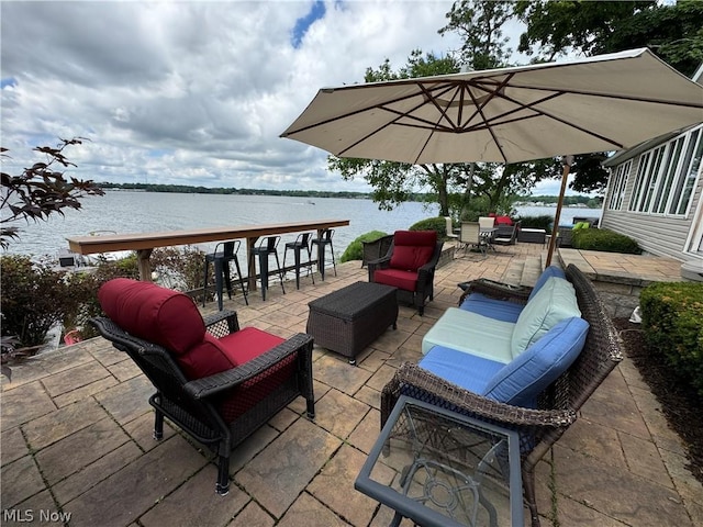 view of patio / terrace featuring outdoor lounge area, a water view, and exterior bar