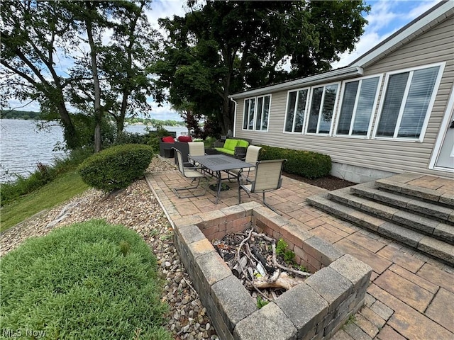 view of patio / terrace with a fire pit and a water view