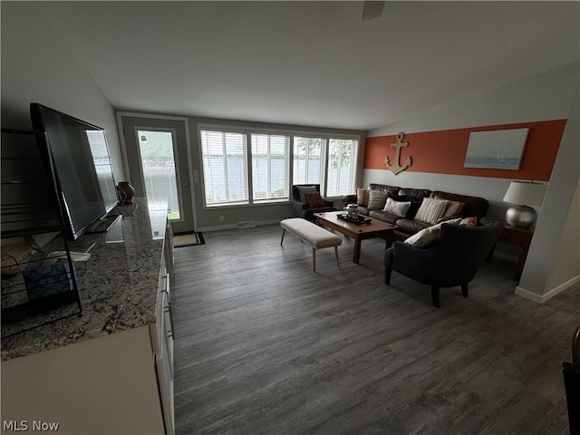 living room with dark hardwood / wood-style floors and vaulted ceiling