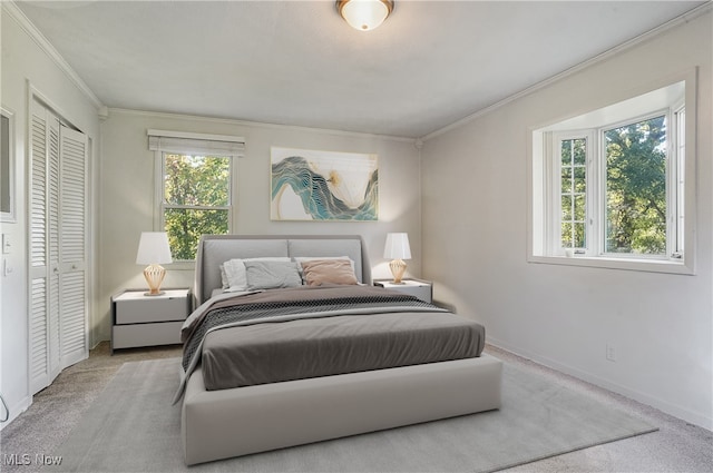 bedroom with a closet, light colored carpet, and ornamental molding