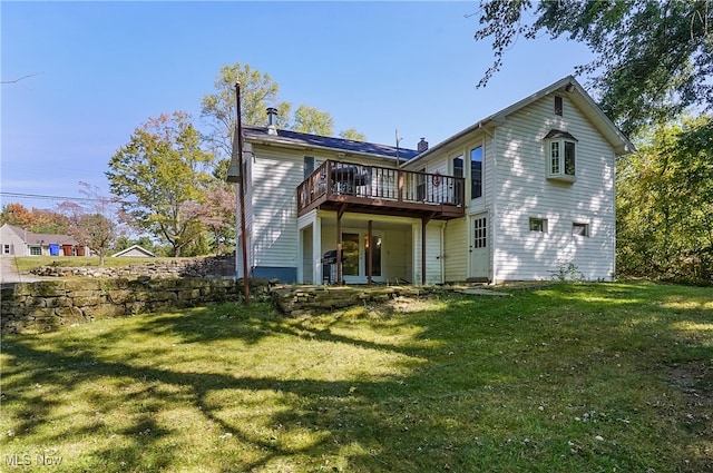 rear view of house with a lawn and a wooden deck