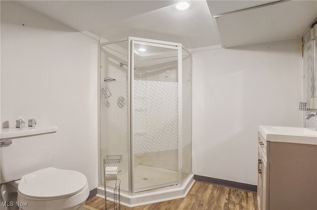 bathroom featuring vanity, hardwood / wood-style flooring, toilet, and an enclosed shower