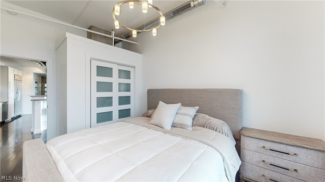 bedroom with dark hardwood / wood-style flooring and built in fridge