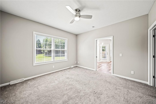 unfurnished bedroom with carpet floors, a ceiling fan, visible vents, and baseboards