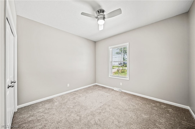 carpeted spare room featuring ceiling fan