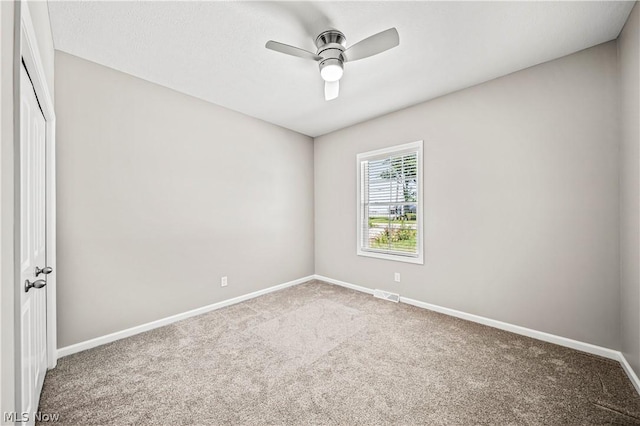 carpeted empty room featuring visible vents, ceiling fan, and baseboards