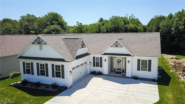 view of front of house with a garage, concrete driveway, a shingled roof, and a front yard