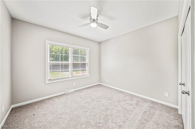 unfurnished room featuring a ceiling fan, carpet, visible vents, and baseboards