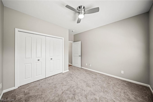 unfurnished bedroom featuring carpet floors, a closet, a ceiling fan, and baseboards