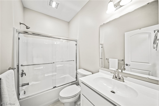 full bathroom featuring combined bath / shower with glass door, toilet, and vanity