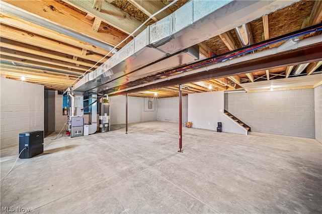 basement featuring heating unit and water heater