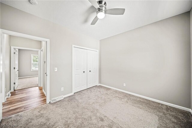 unfurnished bedroom featuring a closet, carpet floors, and ceiling fan