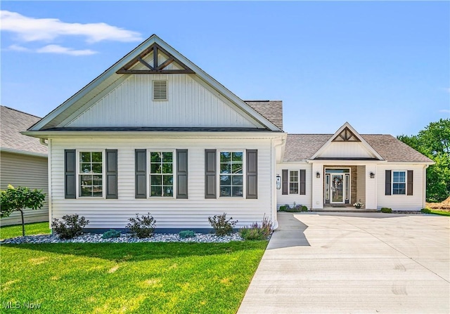 view of front of property with a front yard and roof with shingles