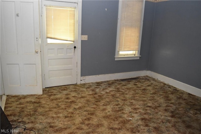 entryway featuring baseboards and carpet flooring