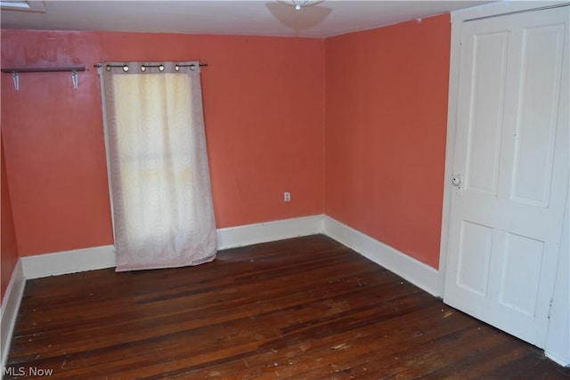 unfurnished bedroom featuring dark wood-type flooring and baseboards