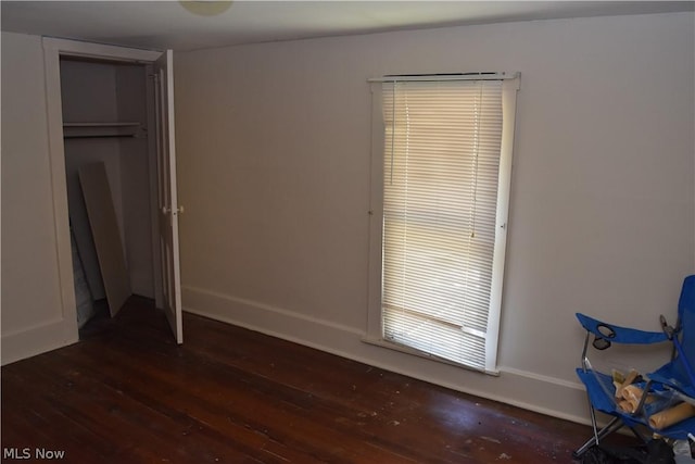 unfurnished bedroom featuring dark wood finished floors and baseboards