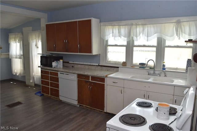 kitchen with white appliances, dark wood-type flooring, a sink, visible vents, and light countertops