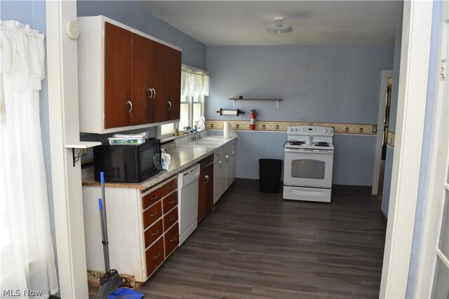 kitchen with sink, dark wood-type flooring, and white appliances