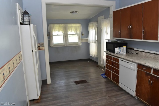 kitchen featuring light countertops, visible vents, dark wood-type flooring, white appliances, and baseboards