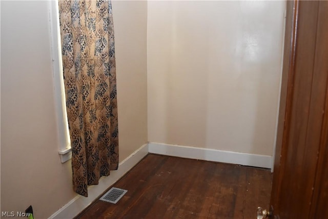 interior space with dark wood-style floors, visible vents, and baseboards