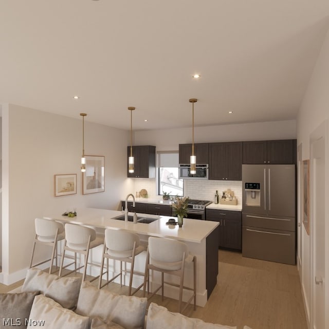 kitchen with stainless steel appliances, light wood-type flooring, sink, a breakfast bar area, and dark brown cabinetry