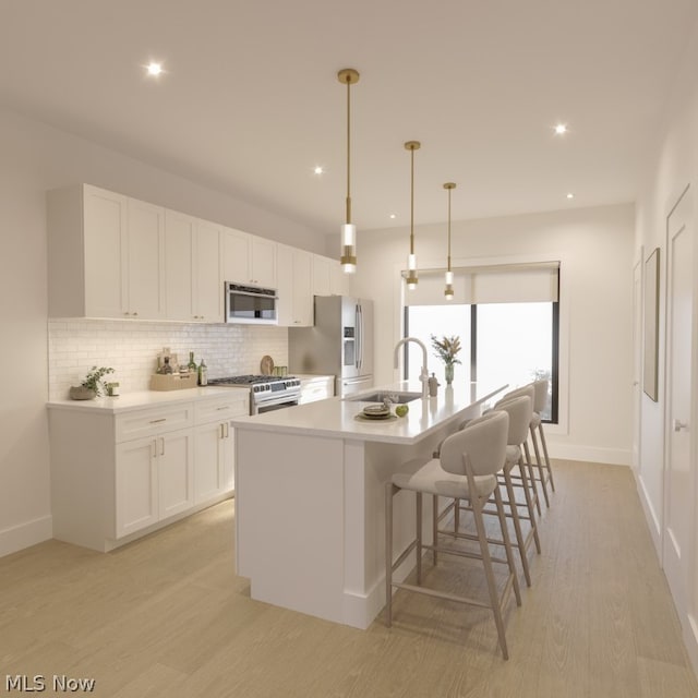 kitchen featuring range with gas stovetop, tasteful backsplash, white cabinets, light wood-type flooring, and a kitchen island with sink