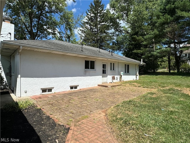 rear view of property with a patio and a lawn