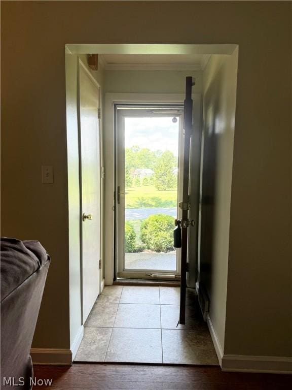 entryway featuring light tile patterned floors, baseboards, and ornamental molding