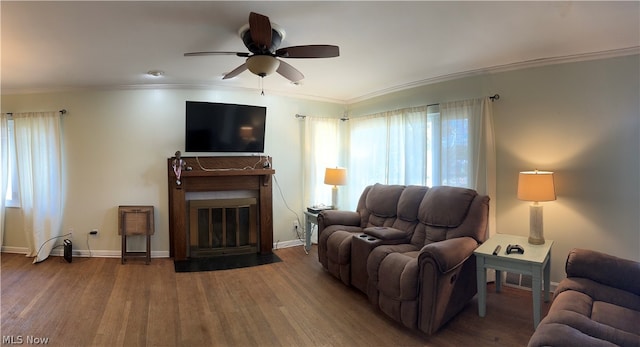 living room featuring dark hardwood / wood-style flooring, ornamental molding, and ceiling fan