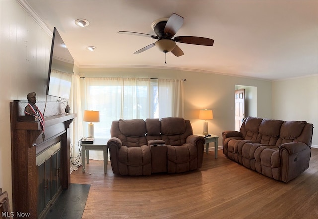 living room featuring dark hardwood / wood-style flooring, ceiling fan, and crown molding