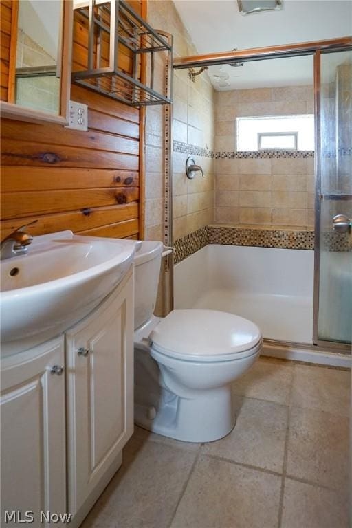 bathroom featuring toilet, vanity, and a shower with door