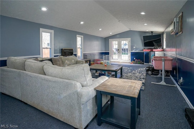 carpeted living room with vaulted ceiling, french doors, and a textured ceiling