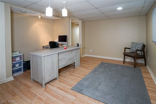 office featuring light hardwood / wood-style floors and a paneled ceiling